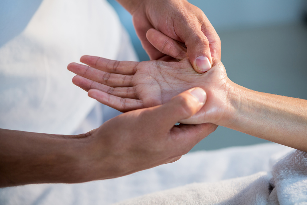 Évaluation de la douleur à la main avec un physiothérapeute de CORPEO